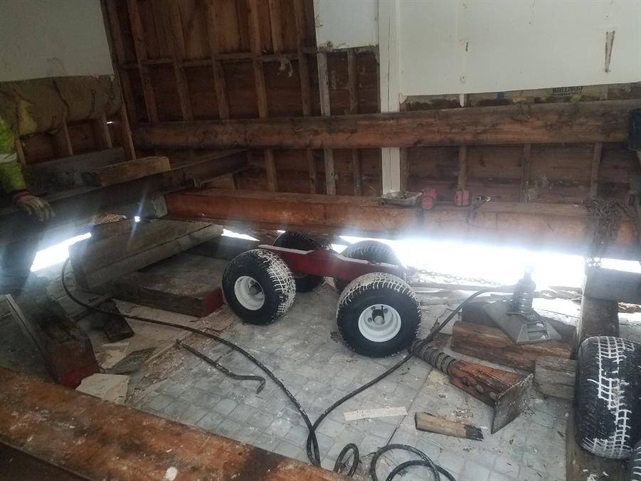 Looking down at the moving dolly's wheeled undercarriage from inside the stripped building