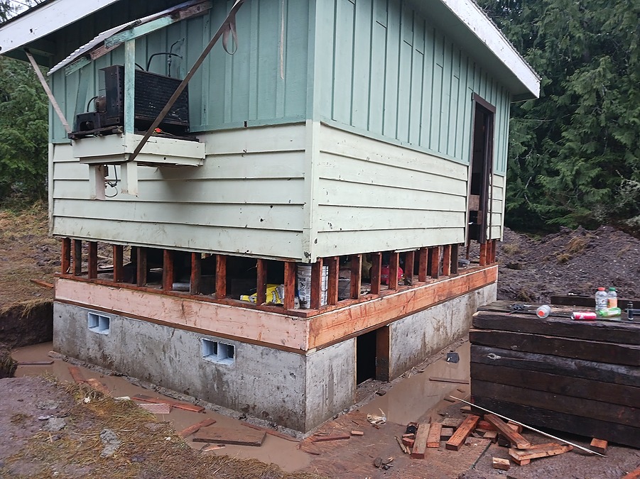 The small building set on its new foundation with vents installed