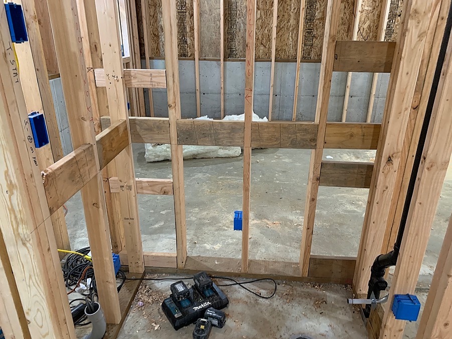 Framed bathroom wall against the original poured foundation