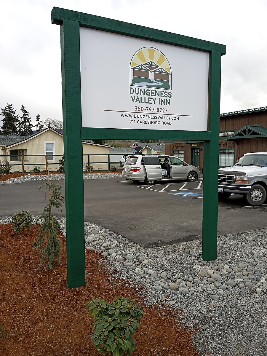 Roadside sign for the Dungeness Valley Inn in front of the renovated building