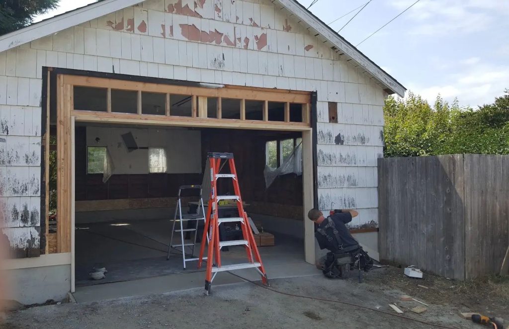 The garage set back down on its new slab and foundation, with a newly framed header over the door opening