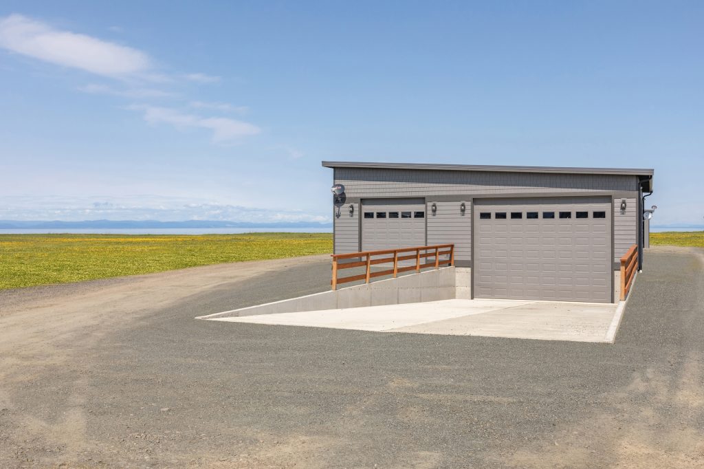 Detached two-bay garage on open acreage with the Strait of Juan de Fuca in the background
