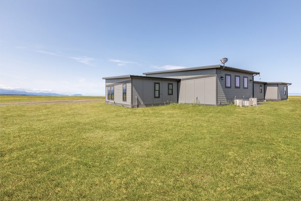 Rear elevation of a modern custom home set on open acreage near the water