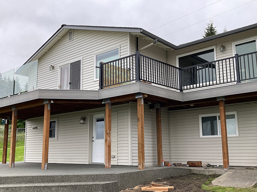 New elevated deck with black railing and glass panel on the same Bell Hill home
