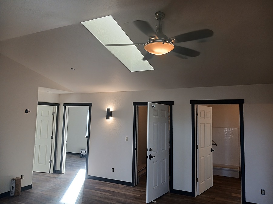 Common room inside the converted veterans housing, with a skylight and doors to bedrooms and a bath